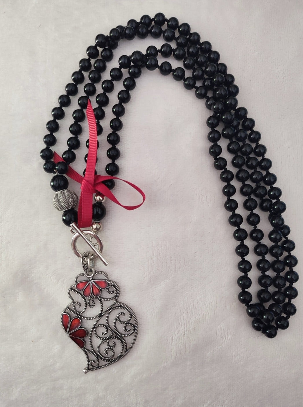  Sautoir collier portugais en perles de couleur noir avec pendentif Cœur de Viana, coração de Viana en filigrane et gouttes rouges, & petit ruban rouge, réalisé à la main,  fabriqué au Portugal,