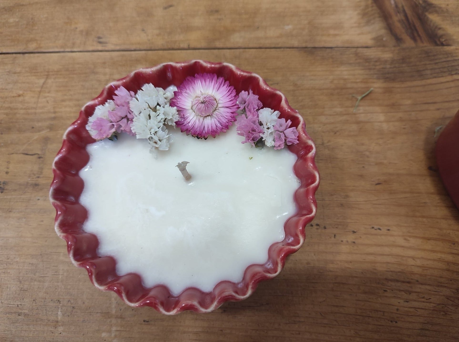 bougie à la cire de soja 100% végétale, coulée dans une céramique portugaise rouge en forme de corolle, avec des petits fleurs séchées. Made in Portugal